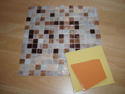 Passendes Mosaik-Material. Glasierte keramische Wandfliesen und Perlmutt-Glassteine auf einem Netzblatt. 