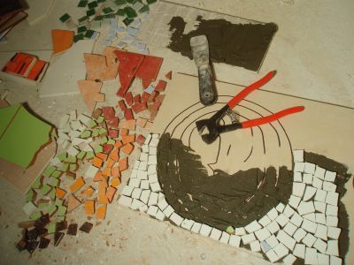 Die Anfangsetappe beim Kleben des Mosaiks. Die Mosaiksteinchen und Kleber liegen bereit. Die Anfangsetappe beim Kleben des Mosaiks. Die Mosaiksteinchen und Kleber liegen bereit.