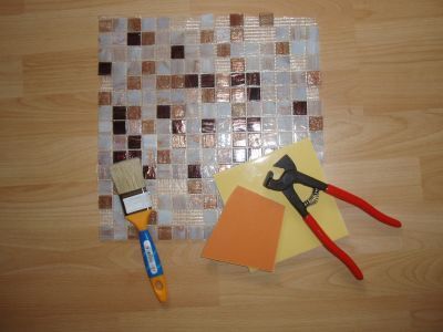 Schneidezange für Fliesen, Flachpinsel für Kleber, Perlmutt-Glas-Mosaik auf einem Netz. Schneidezange für Fliesen, Flachpinsel für Kleber, Perlmutt-Glas-Mosaik auf einem Netz.